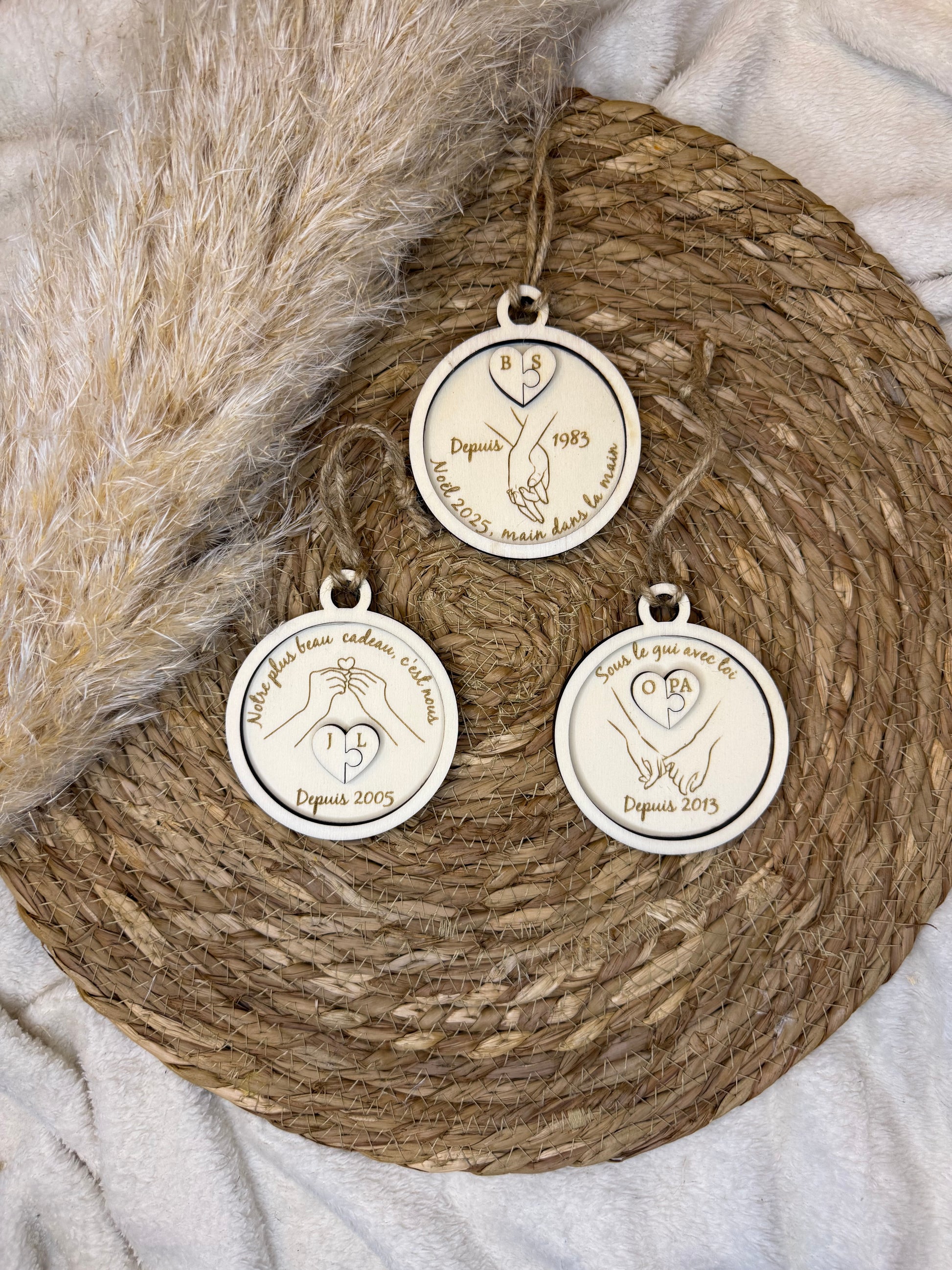 Boule de Noël artisanale en bois présentant deux pièces de puzzle gravées avec les initiales des amoureux, idéale pour un cadeau unique.