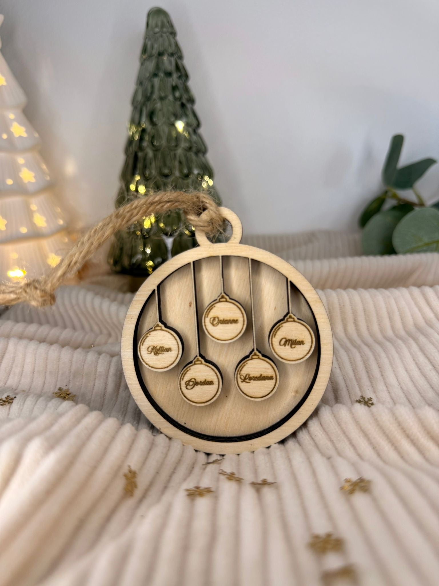 Boule de Noël en bois personnalisée avec les prénoms de la famille, parfaite pour décorer le sapin avec une touche artisanale.