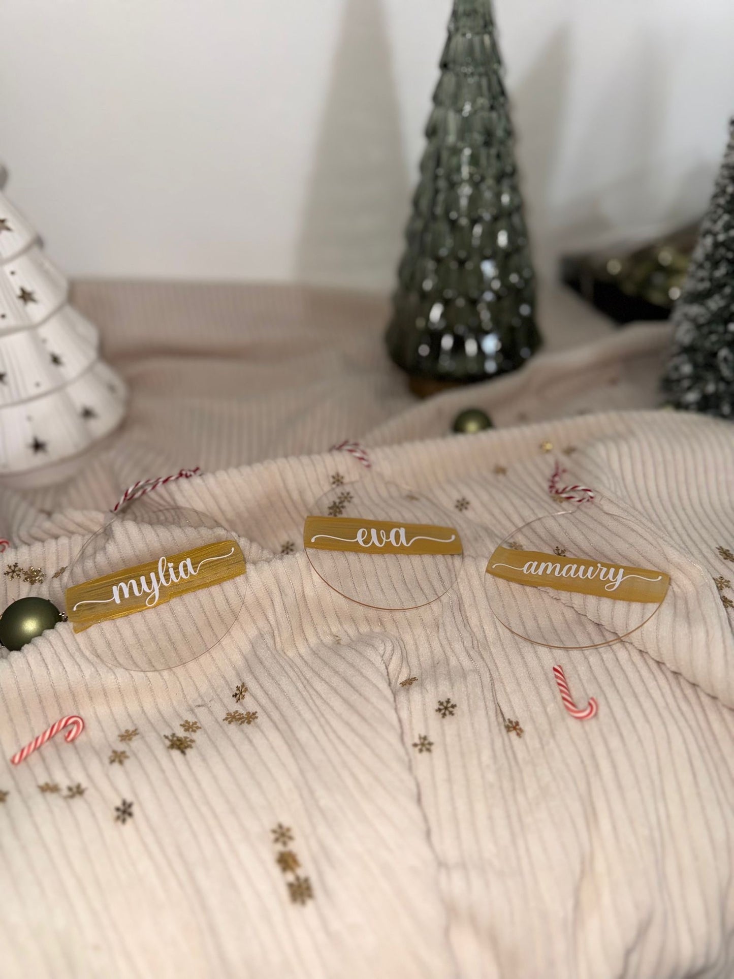 Boule de Noël en acrylique transparent gravée avec un prénom, reflet lumineux et design minimaliste.