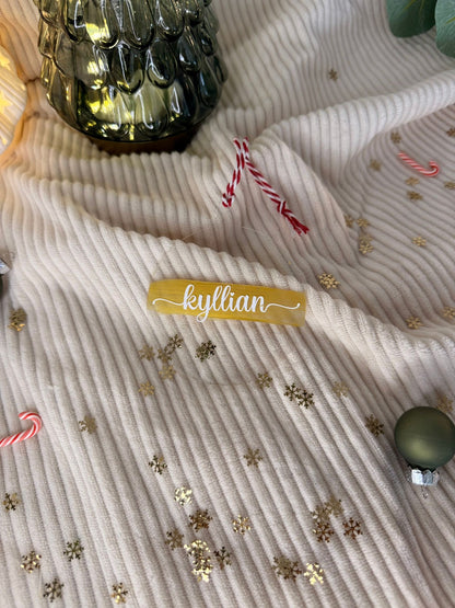 Boule de Noël transparente personnalisée suspendue dans un sapin illuminé, apportant une touche chic et raffinée à la décoration.