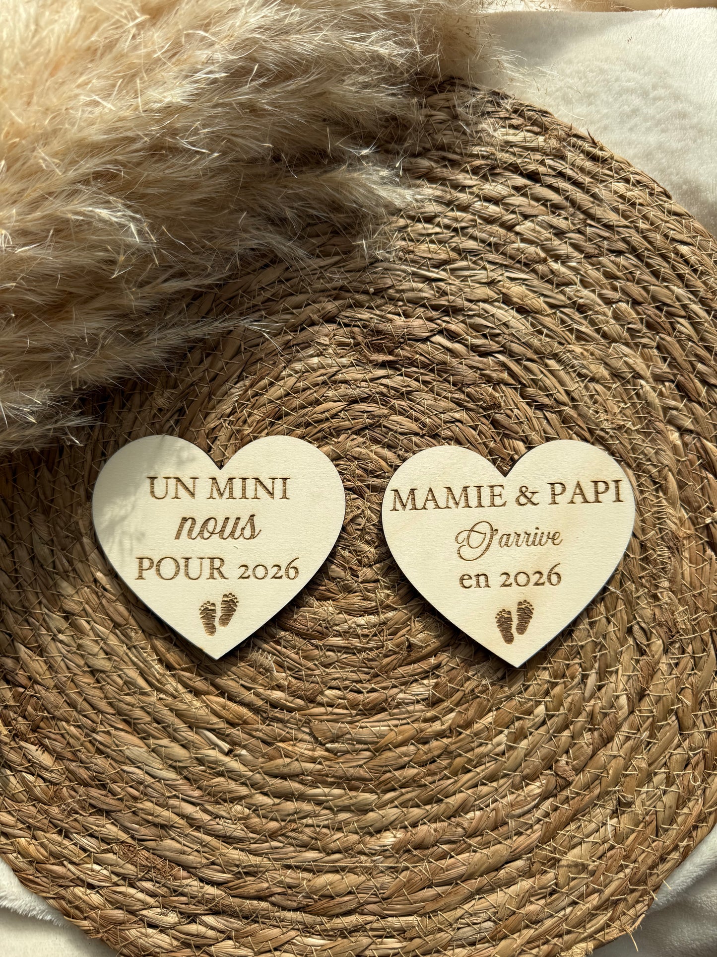 Gros plan sur une carte en bois en forme de cœur gravée avec un prénom et un message de bienvenue, fabrication artisanale.