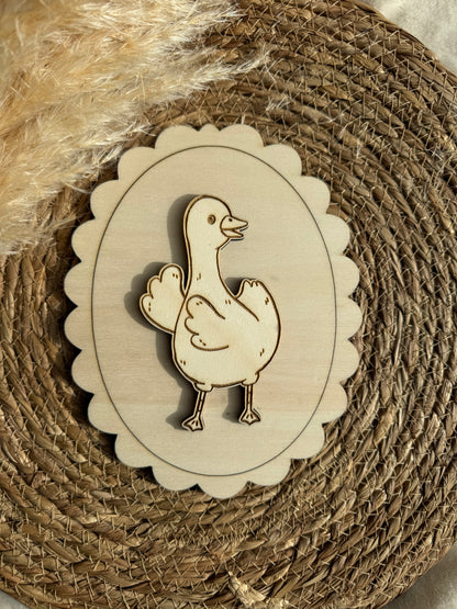 Décoration murale en bois en forme d’oie accrochée au mur d’une chambre de bébé, pour une touche poétique et naturelle.