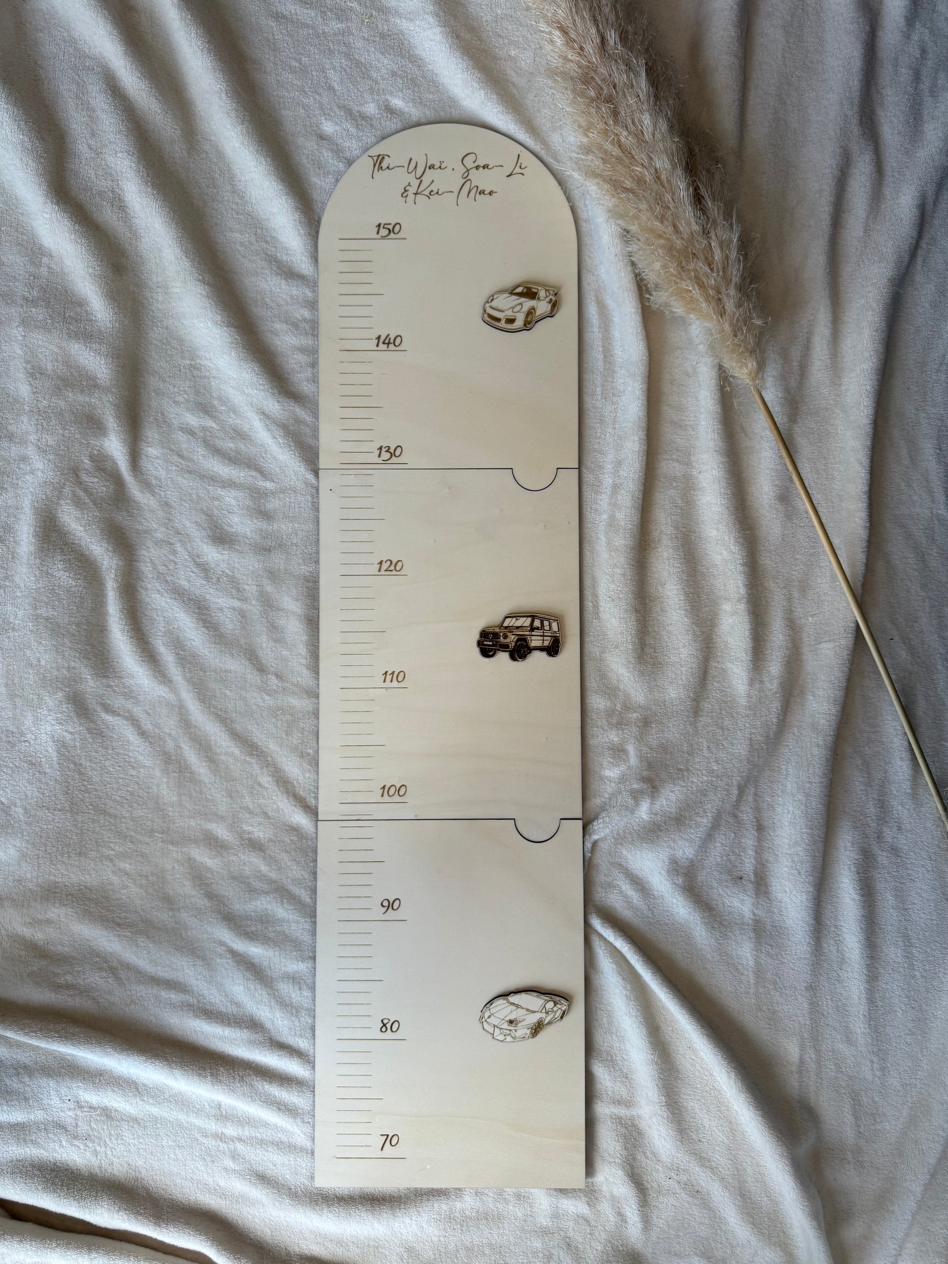 Toise murale en bois sur le thème voiture de course installée dans une chambre de petit garçon, pour une déco ludique